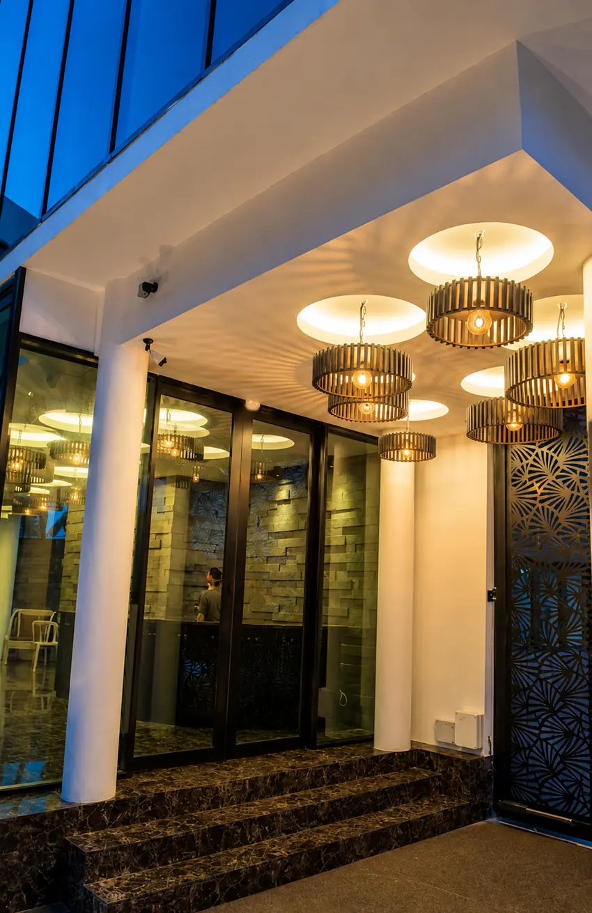 Pintu masuk Hermitage Boutique House dengan tangga marmar dan lampu gantung